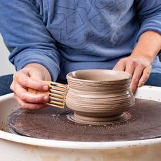 a person is working on a pottery bowl