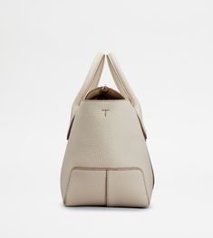 A central ribbing and tubular handles characterize this elegant shopping bag with Tod's logo stamped on the front. Featuring an internal pouch and removable shoulder strap, it is crafted in soft calfskin leather. To accompany with class and femininity your everyday outfits. Classic Cream Bags With Rolled Handles, Modern White Bag With Round Handle, Cream Leather Bags With Rolled Handles, Luxury Beige Satchel With Rolled Handles, Beige Luxury Satchel With Rolled Handles, White Business Shoulder Bag With Detachable Handle, White Shoulder Bag With Detachable Handle For Business, Designer White Bag With Round Handle, Designer White Bag With Rolled Handles