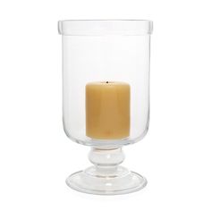 a small glass candle holder with a single lit candle in the middle on a white background