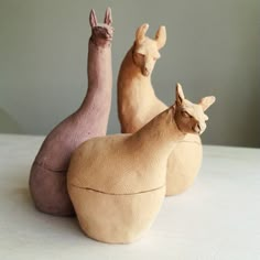 three wooden animals sitting next to each other on a table