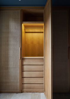 an empty closet with wooden doors and drawers