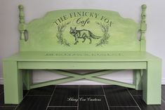 a green bench with the words the finchy fox cafe on it's back