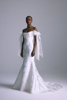 a woman in a white wedding dress posing for the camera