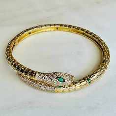 Indulge in luxury with our Sedona Snake Bracelets. Made with top quality 18kg gold filled, these emerald studded cuffs exude sophistication and won't tarnish. Affordable and beautiful, elevate your style with a touch of serpentine elegance. Luxury Snake Shape Bracelets For Women, Green Luxury Bangle Jewelry, Gold Bangle With Emerald As Gift, Gold Emerald Bangle As A Gift, Elegant Gold Bangle With Emerald, Luxury Emerald Bangle Jewelry, Formal Emerald Bangle, Yellow Gold Emerald Bangle Bracelets, Yellow Gold Emerald Bangle Bracelet