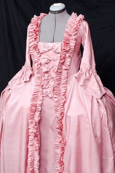 One of the most popular gowns of the 18th century. Here is the fabric tafetta, but If you wish it coud be done of cotton or silk (the fabric price for silk fabric has to be paid extra). The stomacher had to be pinned to the stays traditionally, here I have sewed the dress and the stomacher together. It can be undone if you wisch. The pockets can be reached through the hidden opening on the sides of the dress and petticoat. If this fabric is unavailable at the moment, i will offer you another one Marie Antoinette Style Gown For Costume Party, Pink Victorian Marie Antoinette Costume Dress, 18th Century Style Wedding Dresses With Ruffles, 18th Century Wedding Dress With Ruffles, Pink Rococo Victorian Dress Costume, Pink Victorian Rococo Dress For Costume, Pink Rococo Victorian Dress For Costume, Rococo Style Ruffled Costume Gown, Cotton Dress With Historical Design For Wedding