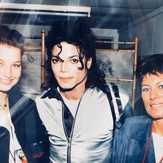 three women standing next to each other in front of a mirror with michael jackson on it