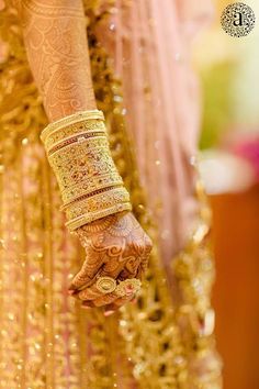 a close up of a woman's hands with gold jewelry