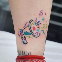 a woman's leg with colorful tattoos on it and a red bracelet around her ankles