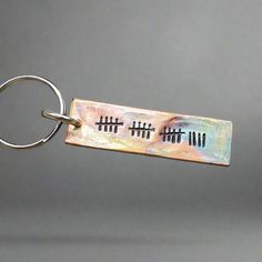 a metal key chain with some writing on it