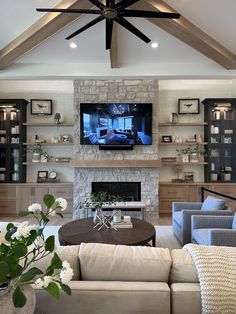 a living room with couches and a television mounted on the wall above it's fireplace