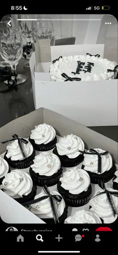 a box filled with lots of cupcakes on top of a black and white table