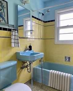 a bathroom with yellow and blue walls, a sink, toilet and bathtub in it