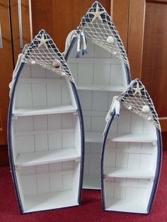 three white boats with blue trims are sitting on a red carpet in front of a wooden door