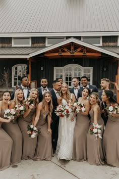 a group of people standing next to each other in front of a building holding bouquets