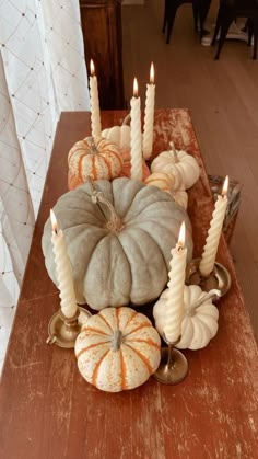 pumpkins and candles are arranged on a table