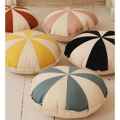 four different colored pillows sitting on the floor