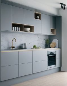 a kitchen with gray cabinets and white counter tops, an oven in the middle is shown