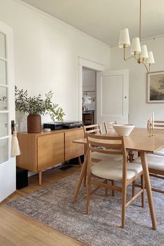 a dining room table and chairs in front of a window