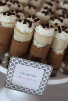 there are many desserts on the table with name tags in front of each one