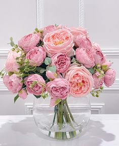 a vase filled with pink flowers on top of a table