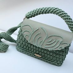 a green handbag sitting on top of a white table