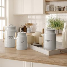 three canisters sitting on top of a kitchen counter