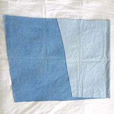 a piece of blue and white fabric on top of a tablecloth with two different colors