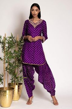 Purple silk kurta with all over bandhani patterns and gota patti embroidered embellishments. Comes with matching patiala. Components: 2 Pattern: Embroidered Type Of Work: Bandhani,Floral Neckline: V-neck Sleeve Type: Three quarter Fabric: Silk Color: Purple Other Details:  Attached lining Length: Kurta: 33 inches Pants: 42 inches Disclaimer: These are made to order designer styles, hence expect a slight variation from the image displayed Occasion: Sangeet,Mehendi and Haldi - Aza Fashions Silk Bandhani Dress Pattern, Bandhani Kurta Designs Women, Salwar Models, Bandhani Kurta, Chudidhar Designs, V Neck Kurta, Silk Dress Design