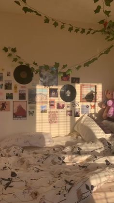 a bed room with a neatly made bed and lots of pictures on the wall above it