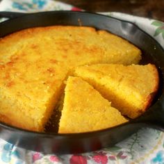 a pan filled with cake sitting on top of a table next to a flowered cloth