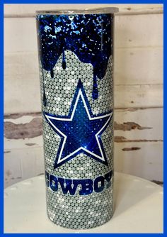 a blue and white tumbler with the word cowboys painted on it's side