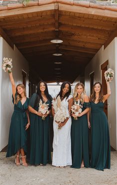 the bridesmaids are holding their bouquets and posing in front of an entrance