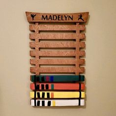 a wooden sign that says madelyn with books stacked on top of eachother