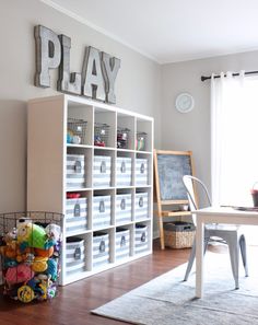 a play room with white shelves filled with toys