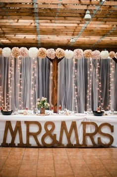 the reception table is decorated with flowers and mr & mrs letters on it's side