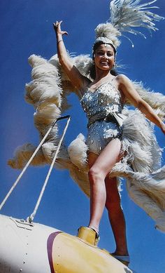 a woman in a costume standing on top of an airplane