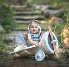 a baby doll sitting on top of a toy airplane