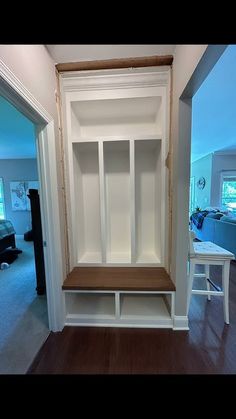 an empty white bookcase in the middle of a living room