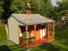 a small wooden shed sitting on top of a lush green field