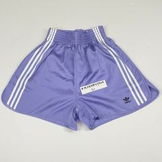 a purple shorts with white stripes on the side and an adidas logo on the front