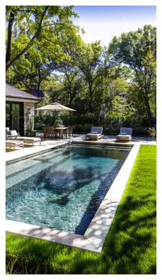 an outdoor swimming pool surrounded by lush green grass