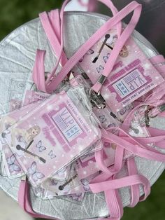 pink and silver purses with tags attached to them on top of a metal plate