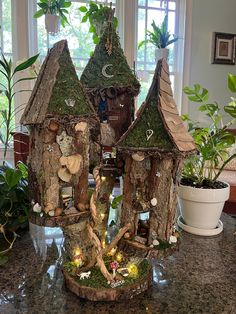 a house made out of tree trunks with fairy lights on the roof and windows behind it