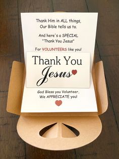 an open box with a thank you card in it on top of a wooden table