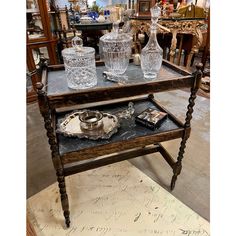 an antique serving table with glassware on it