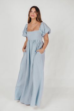 Join us in welcoming the *breathtaking* Candace Maxi Dress to the Worth Collective repertoire - we know you're going to love her! This pastel-hued, 100% linen dress is the epitome of elegance and luxury. Its beautiful neckline frames your decolletage, while the gently puffed sleeves and full skirt accent this gown's exquisite craftmanship. It's the perfect choice for this season's weddings, photo shoots, and other special events! FIT: Runs true to size. Empire waist and smocked bodice will accom Fitted Blue Linen Dress, Blue Fitted Linen Midi Dress, Fitted Linen Maxi Dress For Spring, Fitted Blue Linen Dress For Daywear, Chic Blue Linen Maxi Dress, Blue Maxi Linen Dress, Blue Linen Maxi Dress, Worth Collective, Athleisure Tops