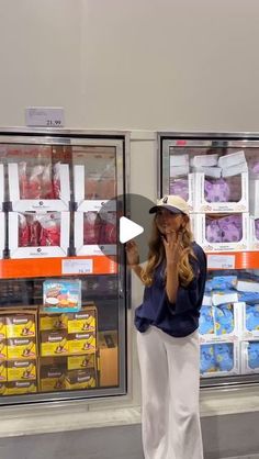 a woman standing in front of a store talking on her cell phone