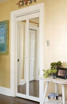 a mirror in the corner of a room next to a table