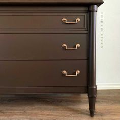 a brown dresser with brass handles and drawers