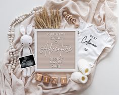 a baby announcement is displayed on top of a blanket with other items and decorations around it